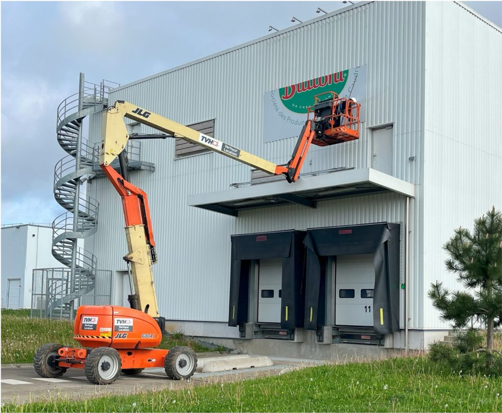 Installation d’enseigne sur façade de bâtiment industriel avec nacelle