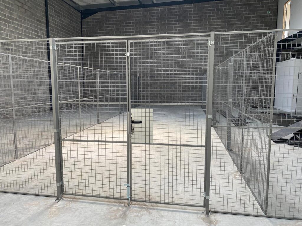 Porte grillagée double permettant l’accès sécurisé à un espace de stockage industriel cloisonné