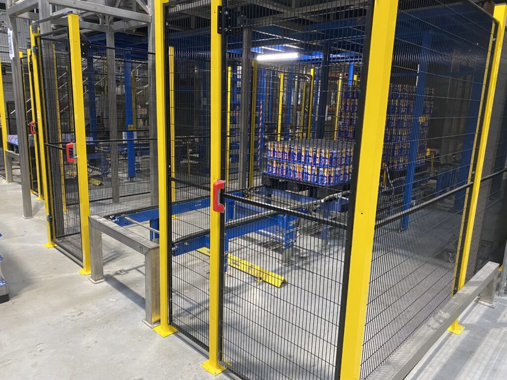 Détail d’une porte d’accès sécurisée intégrée à une cloison grillagée industrielle