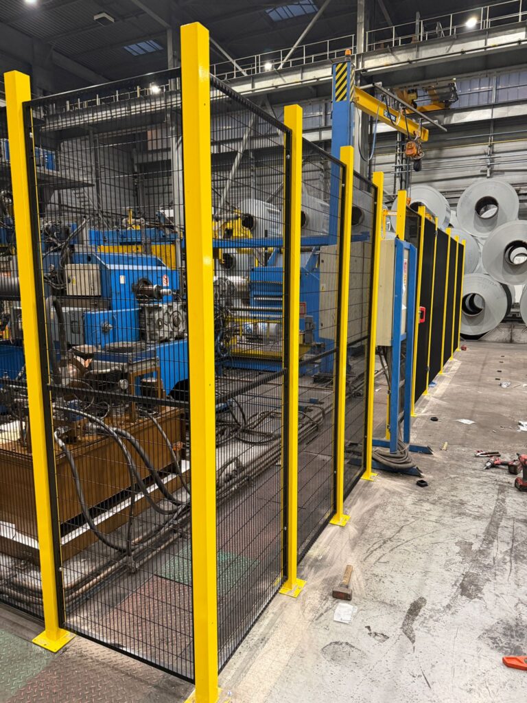 Installation de cloisons grillagées pour sécuriser une machine industrielle dans un environnement de production métallurgique