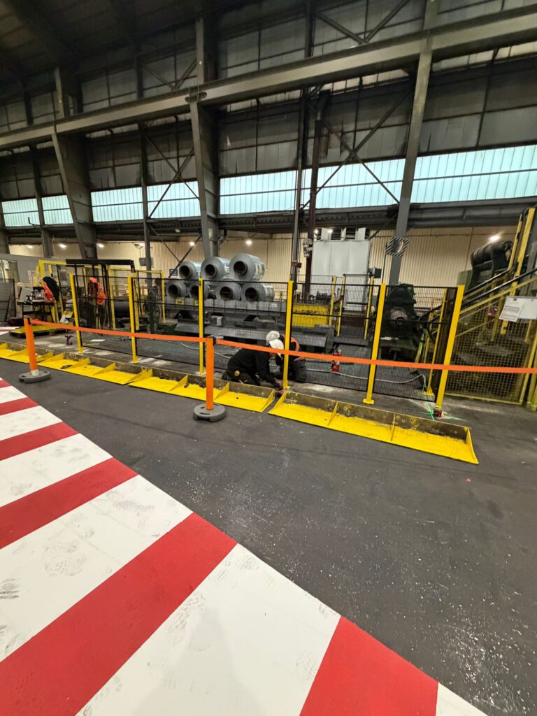 Cloisons grillagées installées pour sécuriser une ligne de production industrielle avec marquage au sol